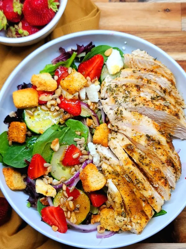 Chicken strawberry salad with fresh greens, grilled chicken, and sliced strawberries