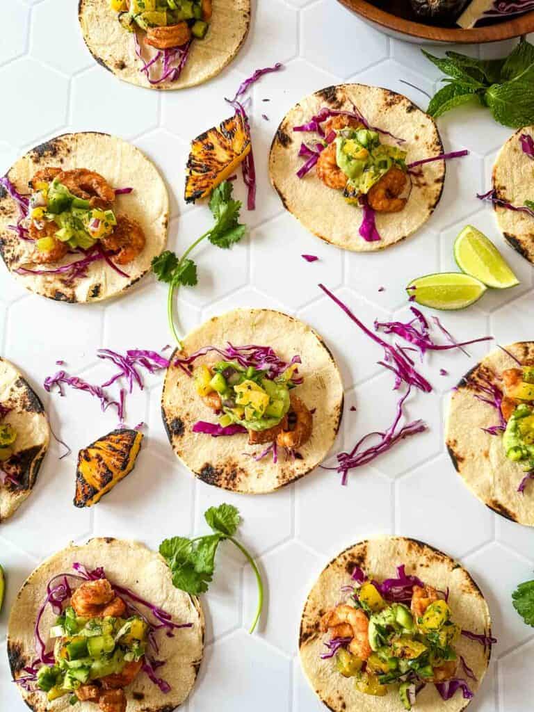 Sheet pan shrimp tacos with roasted pineapple salsa and fresh toppings for a summer dinner