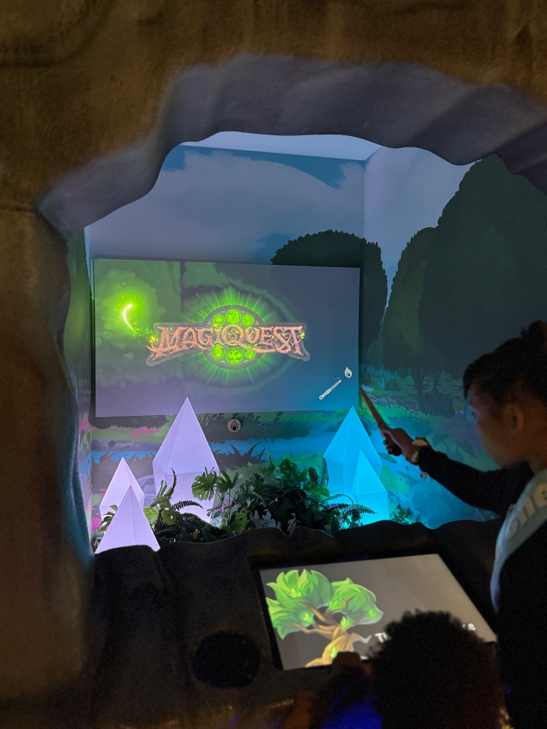 Kids using MagiQuest wands to activate an interactive game screen at Great Wolf Lodge Grapevine in Texas.