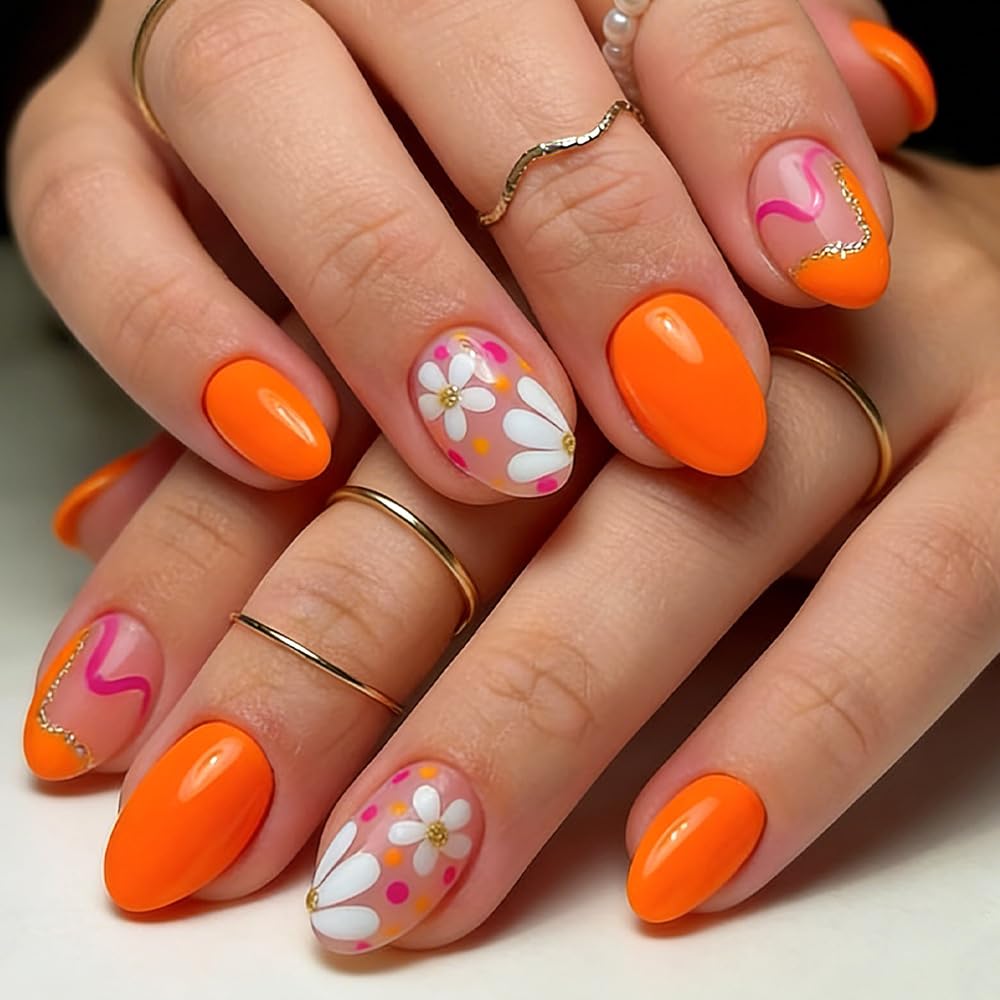 Short bright orange nails with white daisy flower nail art and pink accent details