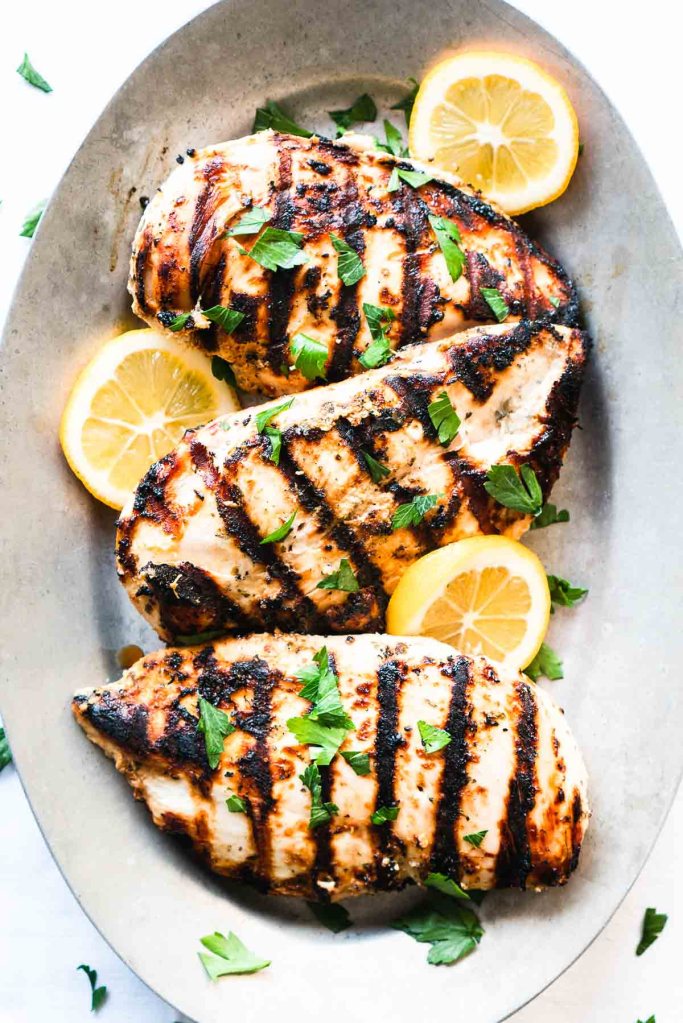 Greek yogurt marinated chicken grilled until juicy for a flavorful summer dinner.