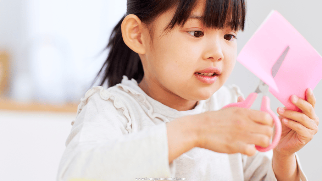 Preschool-aged child practicing cutting paper with child-safe scissors for fine motor development.