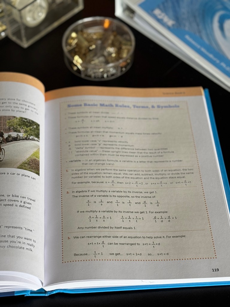 Open textbook page showing basic math rules, terms, and symbols with a bicycle image in the corner.
