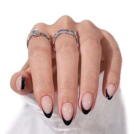Elegant nude nails with sharp black French tips, accessorized with rings.