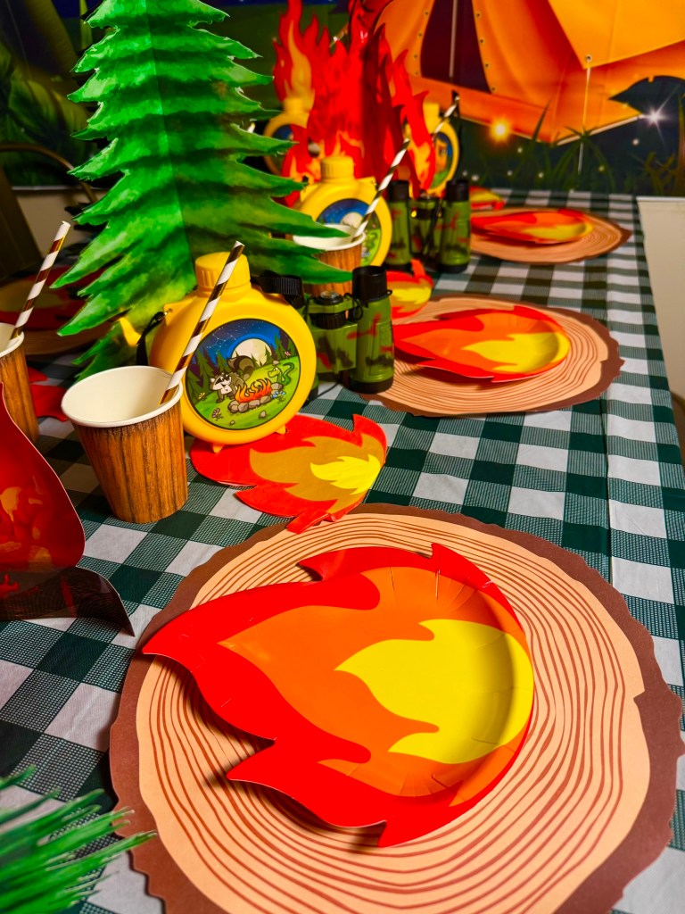 Cozy campfire table centerpiece for an indoor camping themed birthday party.
