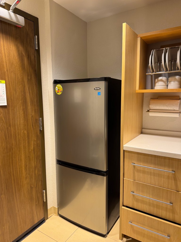 Full-size refrigerator and kitchen storage inside a Home2 Suites Pigeon Forge guest room.