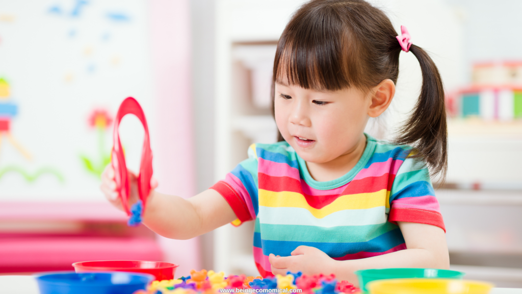 Preschool child sorting colorful objects with tongs for a fine motor learning activity