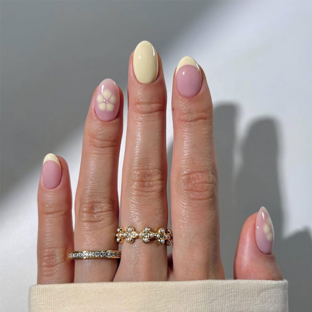 Minimal butter yellow flower accent nails with delicate floral nail art and glossy pastel almond manicure design