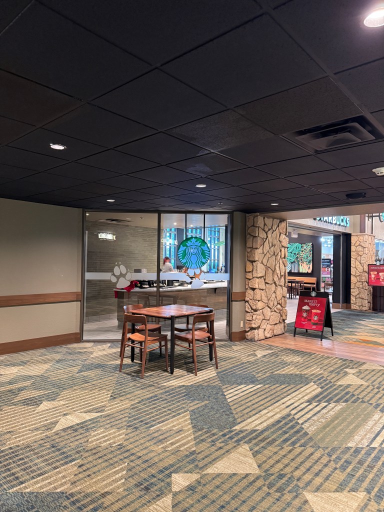 Interior view of Great Wolf Lodge in Grapevine, TX lobby featuring a Starbucks, stone walls, and seating area, highlighting its family-friendly atmosphere.