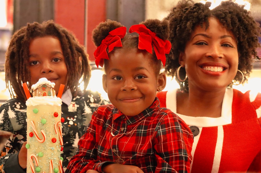 Family posing with Sugar Factory Biloxi's limited-edition Christmas milkshake during a holiday trip to Biloxi, Mississippi.