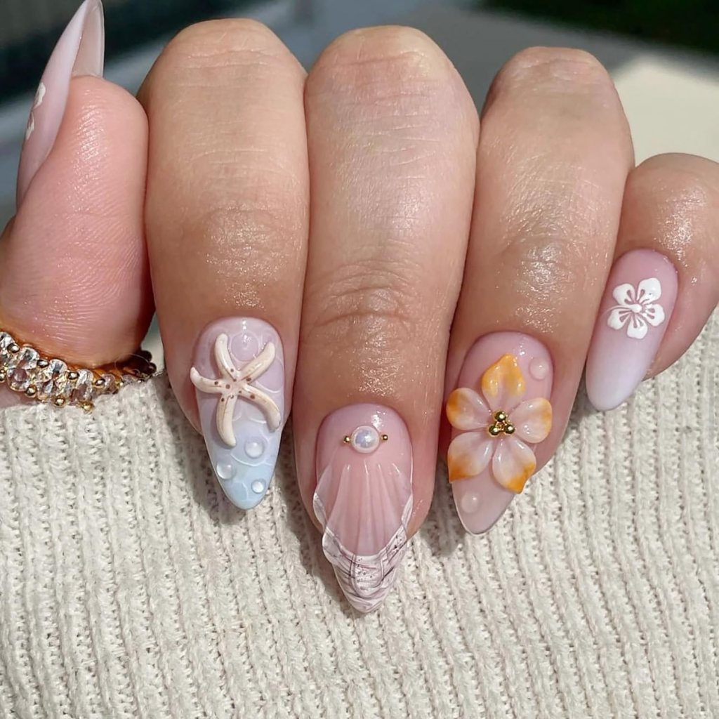 Simple coastal ocean nails with pastel polish, starfish accents, and minimalist beach-inspired shell nail art