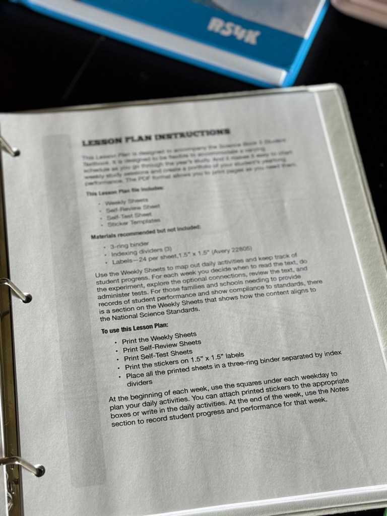 Close-up of lesson plan instructions for a homeschooling science curriculum, including details on weekly sheets, self-review sheets, self-test sheets, and binder organization.