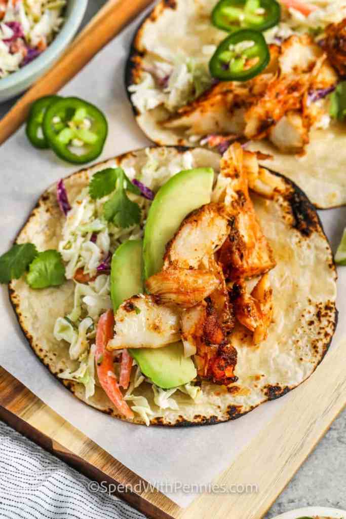 Fish tacos with flaky fish, crunchy slaw, and creamy sauce for a fresh summer dinner.