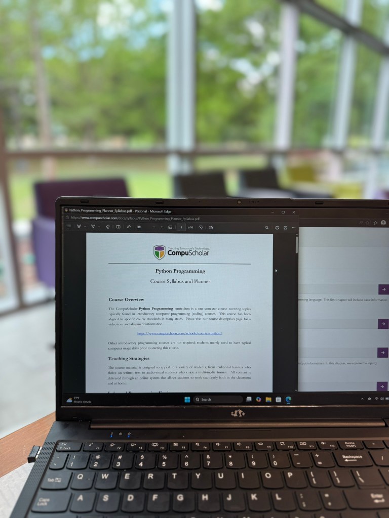 Wide shot of CompuScholar Python course syllabus and planner open on laptop for homeschool curriculum review